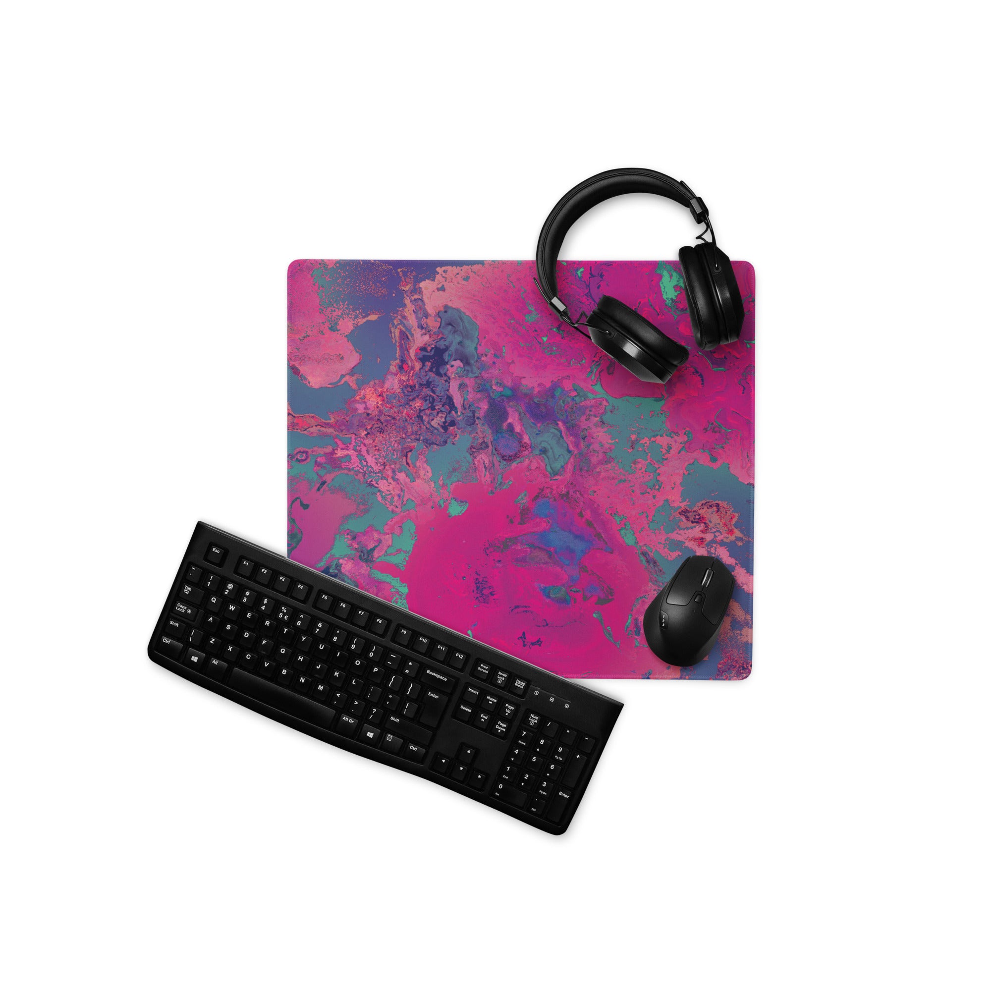 Desk setup with a colorful mouse pad, keyboard, mouse, and headphones on a white background