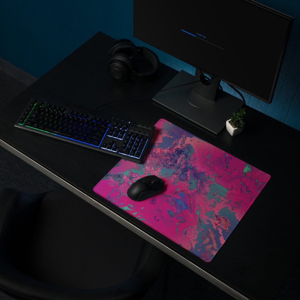 Gaming desk setup with a keyboard, mouse, and monitor on a colorful mouse pad.