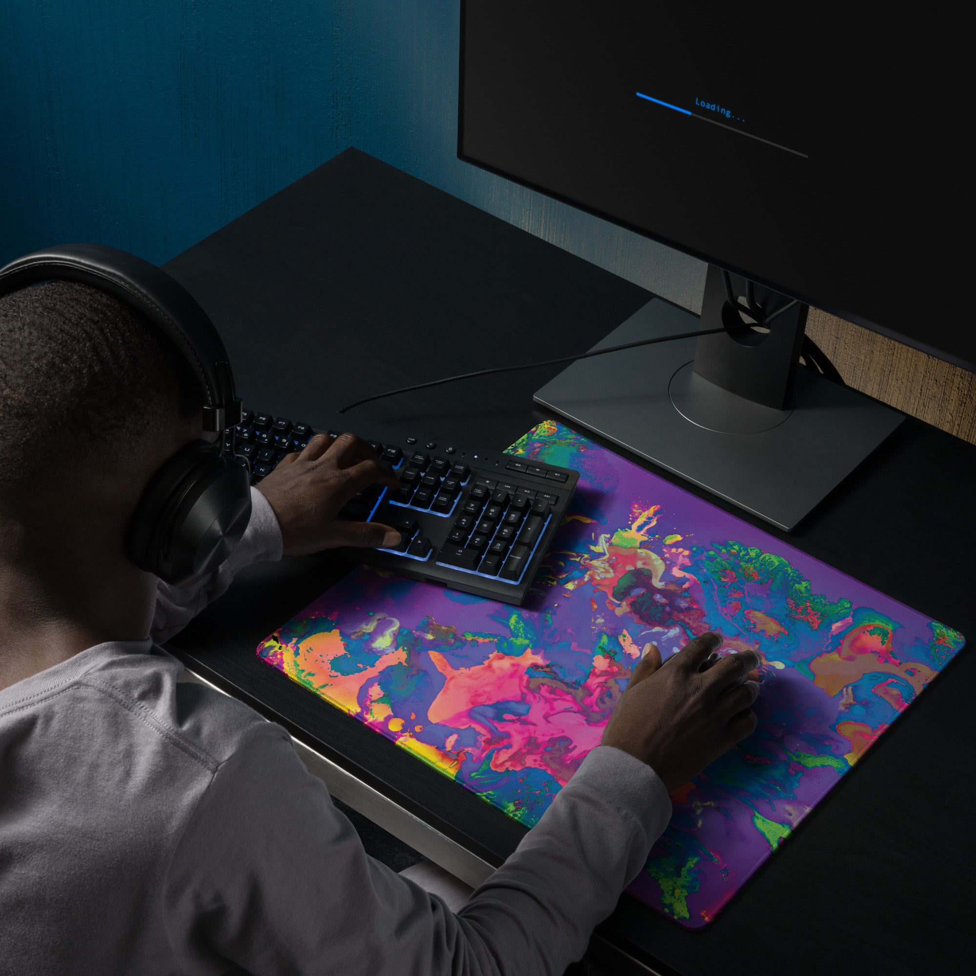 Person using a computer with a colorful mouse pad on a desk