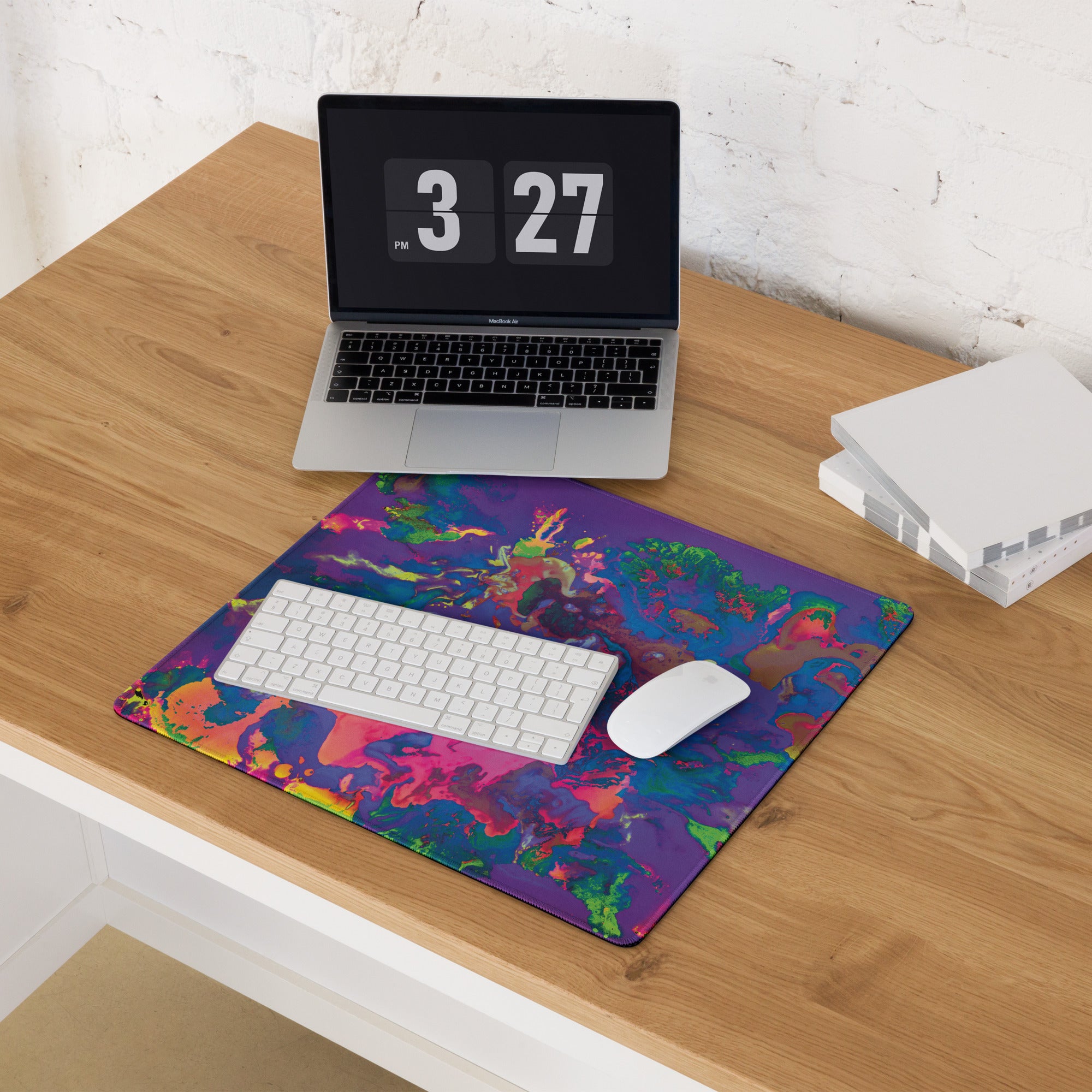 Colorful mouse pad with laptop, keyboard, and mouse on a wooden desk.