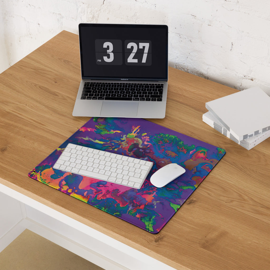 Colorful mouse pad with laptop, keyboard, and mouse on a wooden desk.