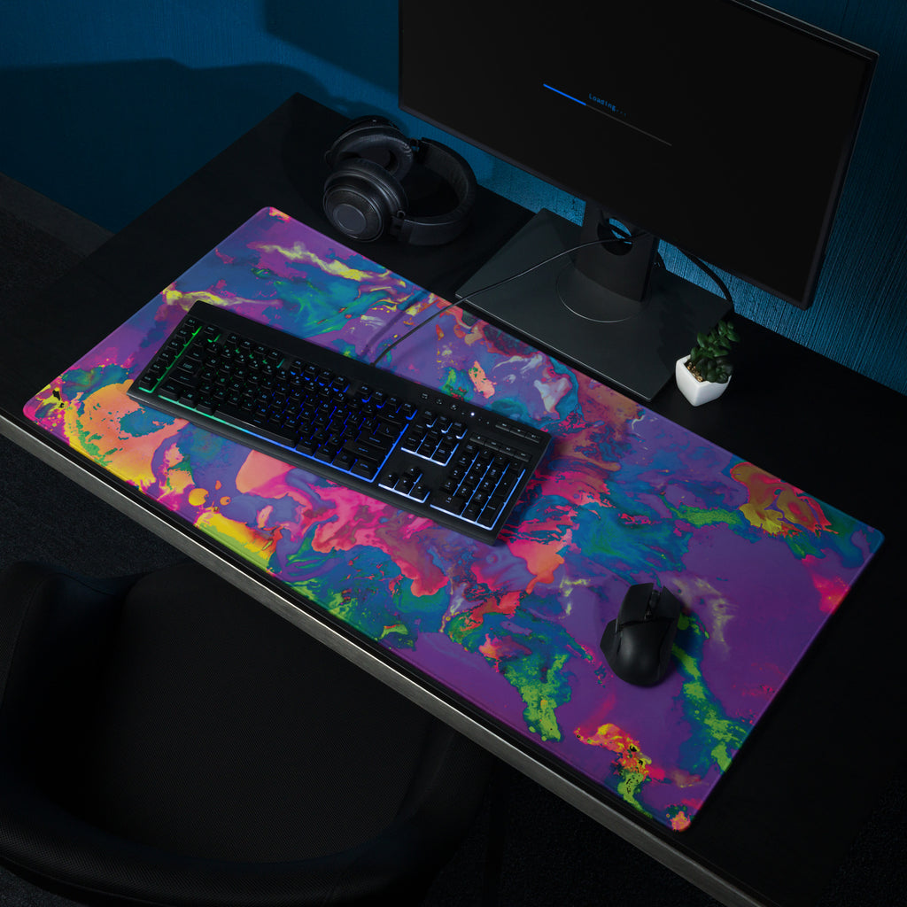Colorful desk mat with keyboard, mouse, and computer setup on a dark surface.