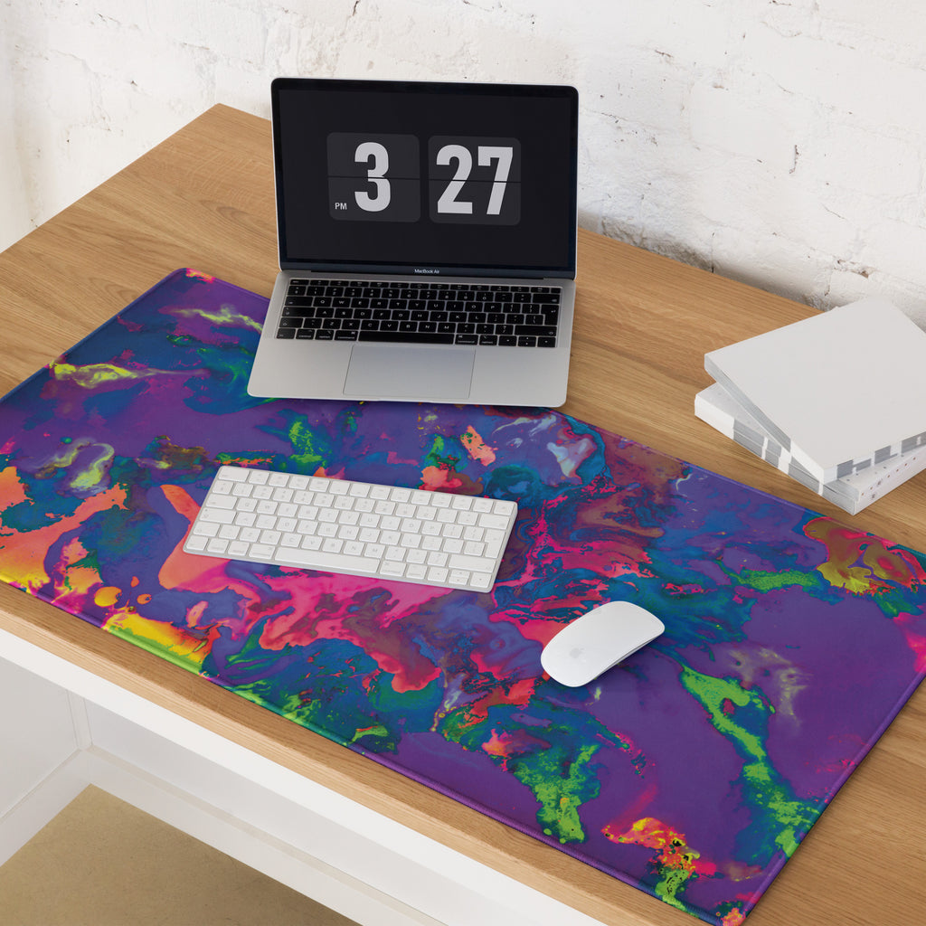 Colorful mouse pad with a laptop, keyboard, and mouse on a wooden desk.