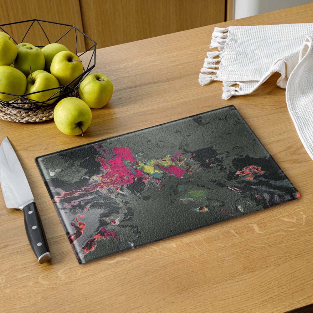 Decorative cutting board with colorful design on a wooden table with apples and a knife.