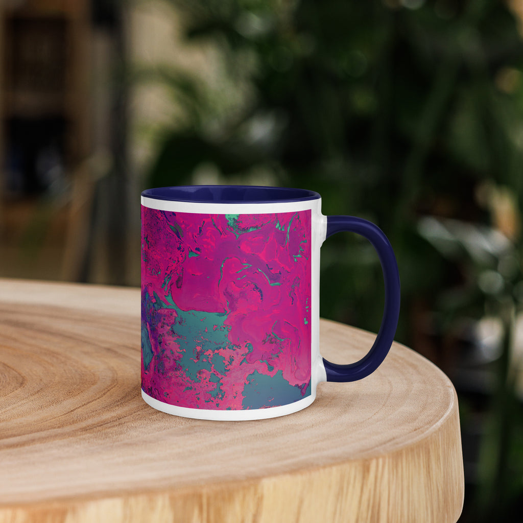 Mug with pink and blue abstract pattern on a wooden surface with a blurred green background